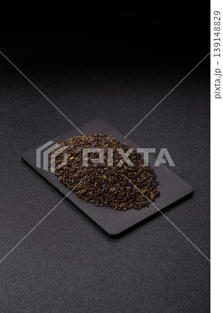 Granules of dried organic Chinese green tea with herbal additives. Dry green tea 139148829