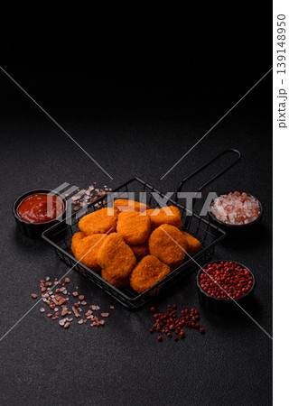 Fried chicken nuggets with sauce, salt, and spices, fast food, unhealthy food. Chicken nuggets Fried chicken nuggets with sauce, salt, and spices, fast food, unhealthy food. Chicken nuggets 139148950