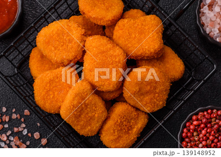 Fried chicken nuggets with sauce, salt, and spices, fast food, unhealthy food. Chicken nuggets Fried chicken nuggets with sauce, salt, and spices, fast food, unhealthy food. Chicken nuggets 139148952