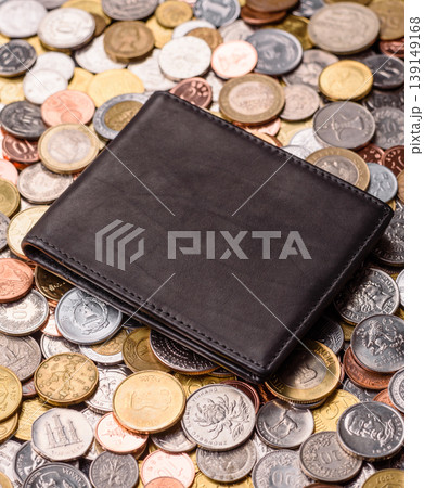 A wallet on the background of silver, gold, and copper coins. Leather wallet 139149168