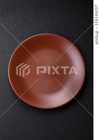 An empty ceramic round plate, kitchen utensils for a dinner table. An empty plate 139149287