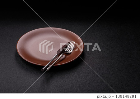 An empty ceramic round plate, kitchen utensils for a dinner table. An empty plate An empty ceramic round plate, kitchen utensils for a dinner table. An empty plate 139149291
