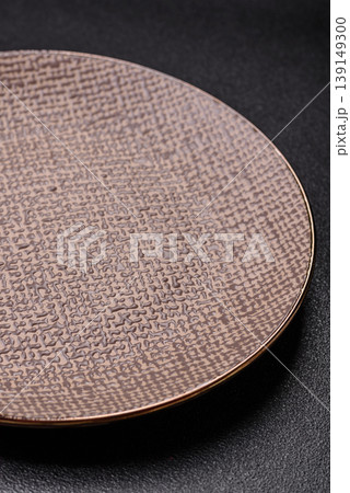 An empty ceramic round plate, kitchen utensils for a dinner table. An empty plate An empty ceramic round plate, kitchen utensils for a dinner table. An empty plate 139149300