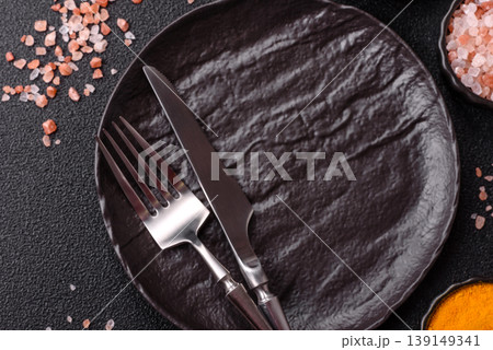 An empty ceramic round plate, kitchen utensils for a dinner table. An empty plate An empty ceramic round plate, kitchen utensils for a dinner table. An empty plate 139149341