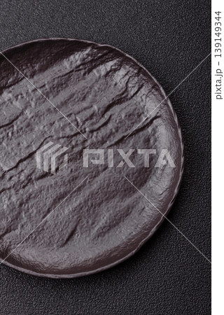 An empty ceramic round plate, kitchen utensils for a dinner table. An empty plate An empty ceramic round plate, kitchen utensils for a dinner table. An empty plate 139149344