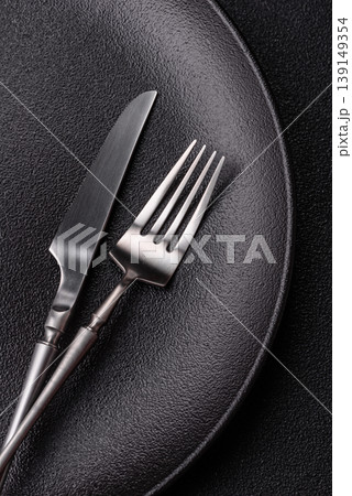 An empty ceramic round plate, kitchen utensils for a dinner table. An empty plate 139149354
