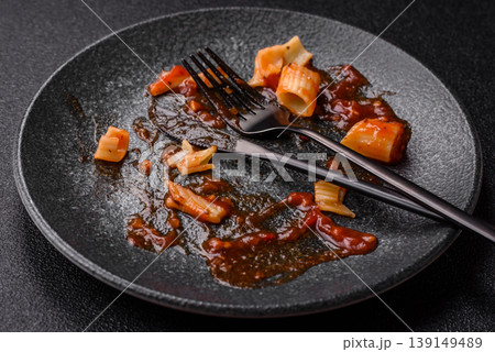 A dirty plate after a meal with leftover pasta and tomato sauce, cleaning. An empty dirty plate A dirty plate after a meal with leftover pasta and tomato sauce, cleaning. An empty dirty plate 139149489