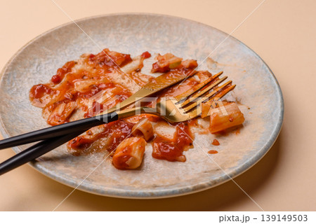 A dirty plate after a meal with leftover pasta and tomato sauce, cleaning. An empty dirty plate A dirty plate after a meal with leftover pasta and tomato sauce, cleaning. An empty dirty plate 139149503