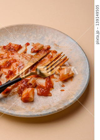 A dirty plate after a meal with leftover pasta and tomato sauce, cleaning. An empty dirty plate A dirty plate after a meal with leftover pasta and tomato sauce, cleaning. An empty dirty plate 139149505