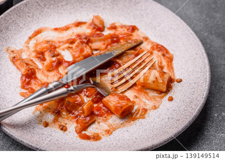 A dirty plate after a meal with leftover pasta and tomato sauce, cleaning. An empty dirty plate A dirty plate after a meal with leftover pasta and tomato sauce, cleaning. An empty dirty plate 139149514