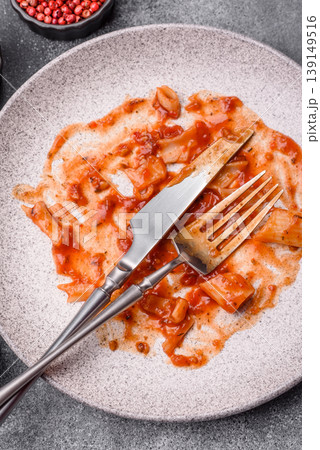 A dirty plate after a meal with leftover pasta and tomato sauce, cleaning. An empty dirty plate A dirty plate after a meal with leftover pasta and tomato sauce, cleaning. An empty dirty plate 139149516