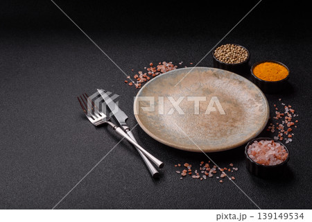 An empty ceramic round plate, kitchen utensils for a dinner table. An empty plate An empty ceramic round plate, kitchen utensils for a dinner table. An empty plate 139149534