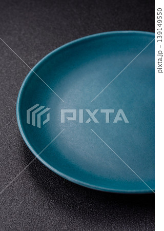 An empty ceramic round plate, kitchen utensils for a dinner table. An empty plate 139149550