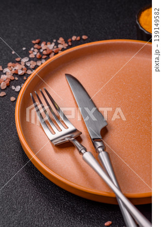 An empty ceramic round plate, kitchen utensils for a dinner table. An empty plate An empty ceramic round plate, kitchen utensils for a dinner table. An empty plate 139149582