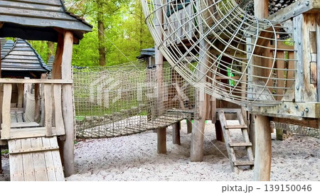 A serene park with a charming wooden playground for children A serene park with a charming wooden playground for children 139150046
