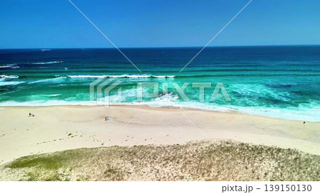 Experience a breathtaking coastal view showcasing rolling waves and a pristine sandy beach Experience a breathtaking coastal view showcasing rolling waves and a pristine sandy beach 139150130