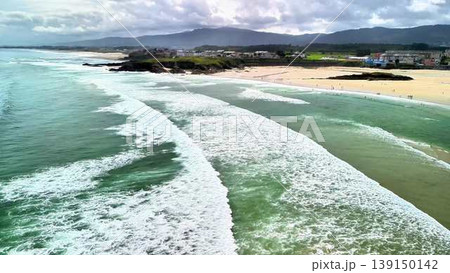 A breathtaking aerial view showcasing the scenic beauty of ocean waves and a picturesque beachfront 139150142