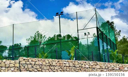 Scenic Outdoor Sports Facility Complete with Netting and Basketball Hoops for Activities 139150156