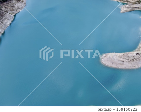 Serene mountain lake, Tranquil alpine body of water with rugged rocky shores and smooth reflective surface Serene mountain lake, Tranquil alpine body of water with rugged rocky shores and smooth reflective surface 139150222