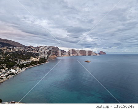 Quiet seaside cove under subdued skies, Peaceful shoreline with soft lighting and distant village views Quiet seaside cove under subdued skies, Peaceful shoreline with soft lighting and distant village views 139150248