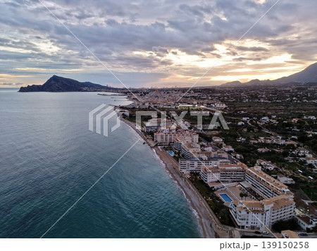 City skyline overview, Panoramic city scene adjacent to shoreline with mountainous background 139150258