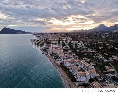 Evening seaside ambiance, Sunset sky with glowing lights, Twilight over coast with vibrant cloud display 139150259