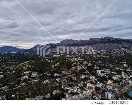 Highaltitude perspective of settlement, Elevated shot featuring clustered homes beneath thick clouds Highaltitude perspective of settlement, Elevated shot featuring clustered homes beneath thick clouds 139150265