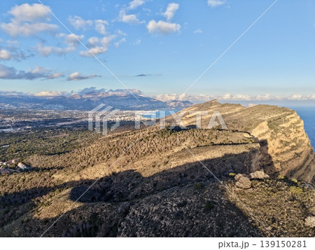 Scenic coastal panorama, Vivid landscape displays majestic cliffs and shimmering ocean under cloudy sky 139150281