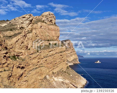 Serene ocean vista, Scenic shoreline view showing ship on serene waters beneath scattered clouds Serene ocean vista, Scenic shoreline view showing ship on serene waters beneath scattered clouds 139150316