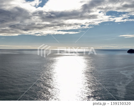Bright reflections over tranquil ocean, Shimmering sunlight follows peaceful water surface scene Bright reflections over tranquil ocean, Shimmering sunlight follows peaceful water surface scene 139150320