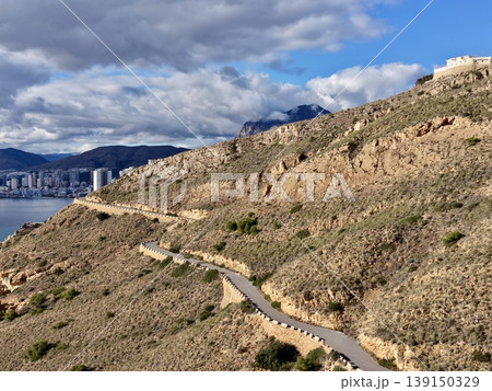 Dramatic sky over craggy cliffs, Foreboding atmosphere with contrasting shadows over rough terrain 139150329