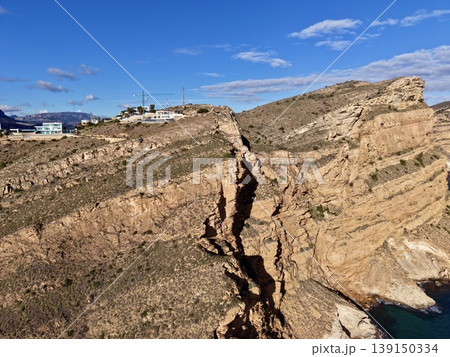 Aerial perspective showcasing geological formations and erosion patterns on rocky seaside cliff Aerial perspective showcasing geological formations and erosion patterns on rocky seaside cliff 139150334