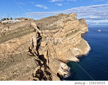 Breathtaking aerial vantage showcasing precipitous coastlines and turbulent ocean currents in vibrant colors 139150335