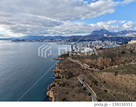 Sunlit seaside skyline, Sunshine bathes coastal town and bay with scenic mountain views from above Sunlit seaside skyline, Sunshine bathes coastal town and bay with scenic mountain views from above 139150351