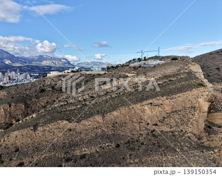 Erecting structures on steep rocky cliffs overlooking vast ocean with safety precautions in place Erecting structures on steep rocky cliffs overlooking vast ocean with safety precautions in place 139150354