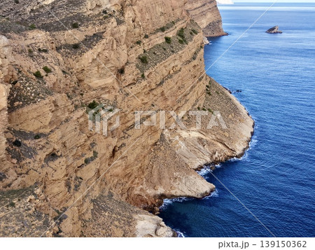 Imposing rock face beside azure sea offering breathtaking vistas and photographic opportunities 139150362