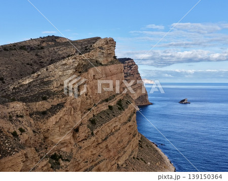 Cliffside horizon with boat, Scenic maritime voyage featuring distant boat and layered terraces 139150364