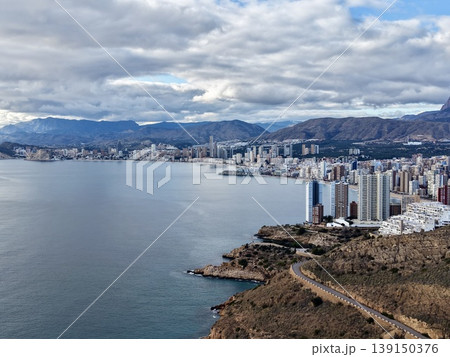 Sunset over rugged coastlines, Golden illuminated cliffs and winding pathways near shimmering waters 139150376