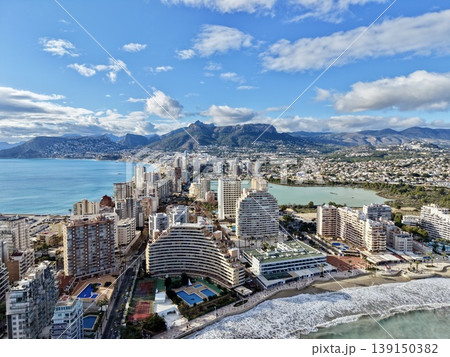 Expansive shoreline scene illustrating rolling surf alongside city development and hotel supervision Expansive shoreline scene illustrating rolling surf alongside city development and hotel supervision 139150382