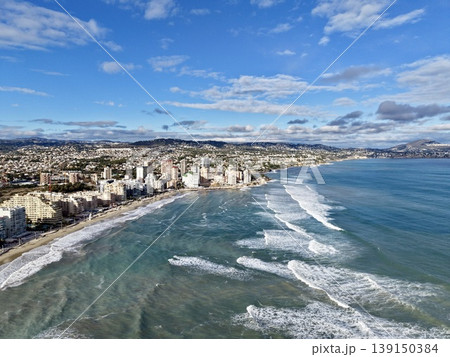 Sunrise over calm beach coast, Aerial perspective of tranquil beach with rising sun and waves Sunrise over calm beach coast, Aerial perspective of tranquil beach with rising sun and waves 139150384