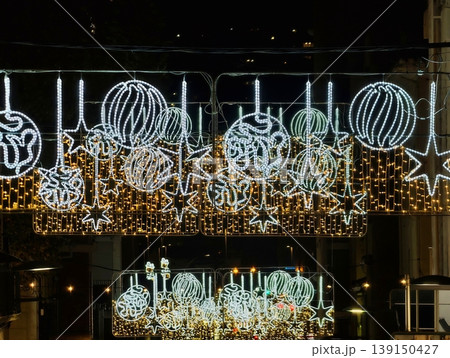Refined decorative lighting display. Artistic lighting enhances upscale nighttime district ambiance Refined decorative lighting display. Artistic lighting enhances upscale nighttime district ambiance 139150427