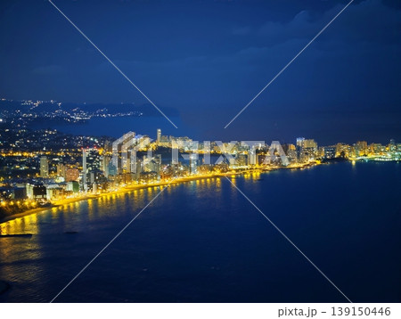 Quiet coast landscape showcasing distant promontory and softly glowing waterfront under twilight sky Quiet coast landscape showcasing distant promontory and softly glowing waterfront under twilight sky 139150446