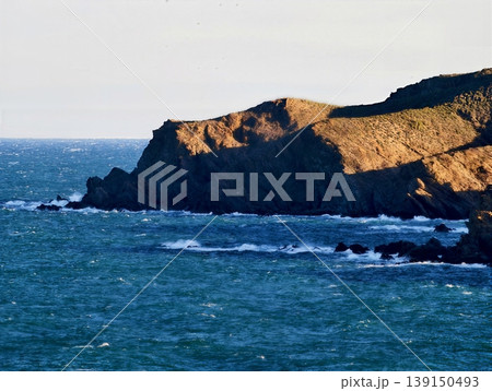 Seaside cliffs with crashing waves. Rugged coastlines overshadowed by fading twilight and crashing surf Seaside cliffs with crashing waves. Rugged coastlines overshadowed by fading twilight and crashing surf 139150493