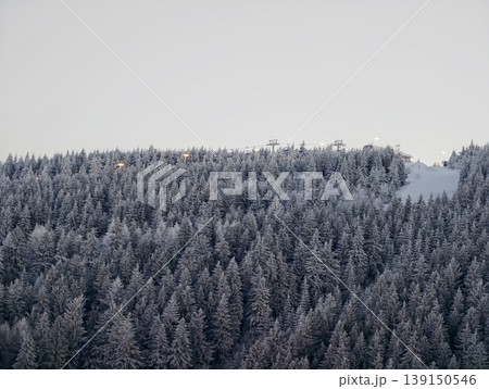 Winter landscape featuring icy tree crowns. Azure sky over frosty evergreen forest with haze Winter landscape featuring icy tree crowns. Azure sky over frosty evergreen forest with haze 139150546
