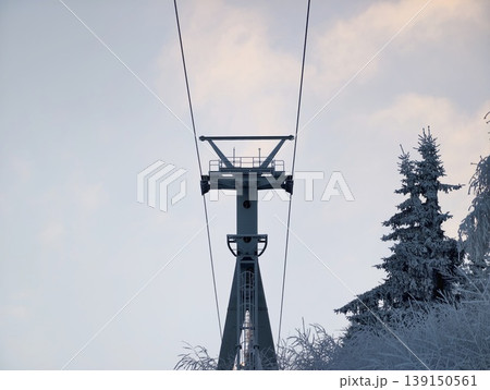 Silhouetted pylons and cables contrast with peaceful dusk sky and tranquil alpine surroundings Silhouetted pylons and cables contrast with peaceful dusk sky and tranquil alpine surroundings 139150561