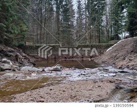 Serene landscape with water and trees. Quiet natural setting featuring mosscovered stones and flowing stream Serene landscape with water and trees. Quiet natural setting featuring mosscovered stones and flowing stream 139150594