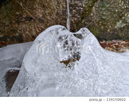 Detailed closeup of sculpted ice displaying central cavity and reflective shimmering surfaces 139150602
