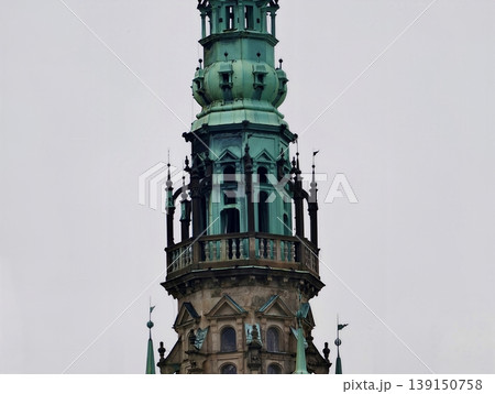 Decorative tower with detailed ironwork. Vertically aligned ornate copper spire with decorative features Decorative tower with detailed ironwork. Vertically aligned ornate copper spire with decorative features 139150758