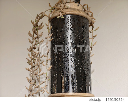 Ceramic lantern with bamboo accents. Decorative lantern featuring perforated patterns and dried vines 139150824