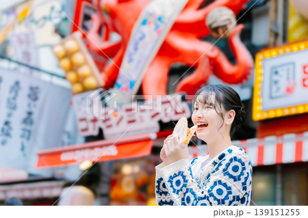 大阪道頓堀で名物のたこせんを食べる女性 大阪道頓堀で名物のたこせんを食べる女性 139151255
